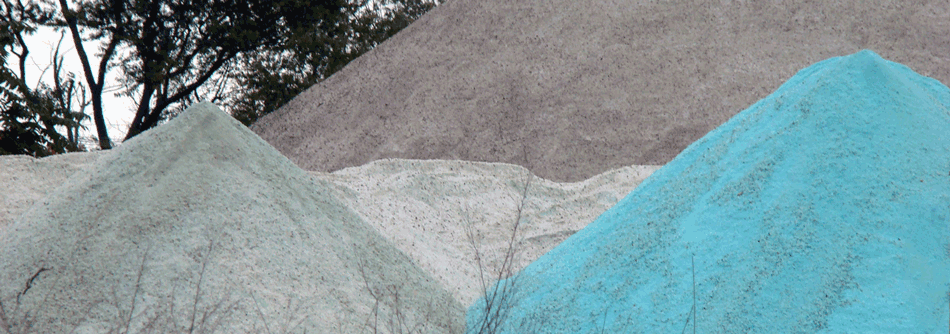 Three large piles of different types of winter salt.