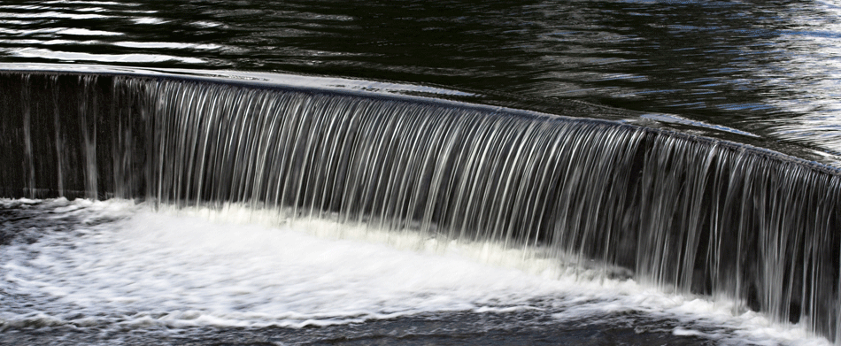 Water flowing over a dam.