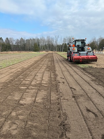 Tractor removing grass and weeds on land to prepare it for seeding